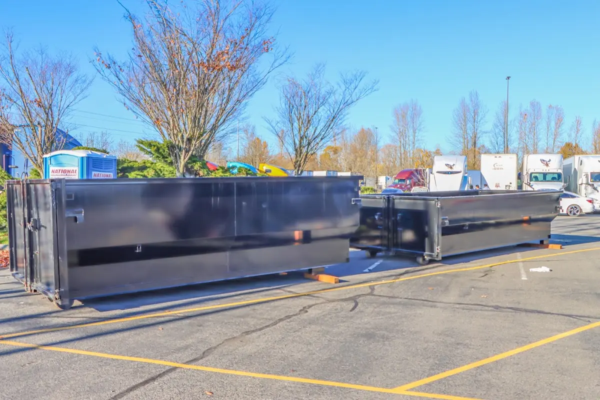 Professional dumpster rental service with roll-off container on residential driveway in Hampden